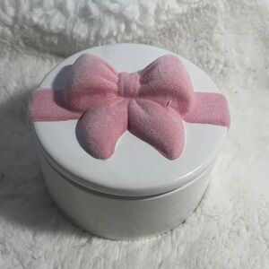 Enchante citrus glow soy wax blend candle in white ceramic jar with pink bow